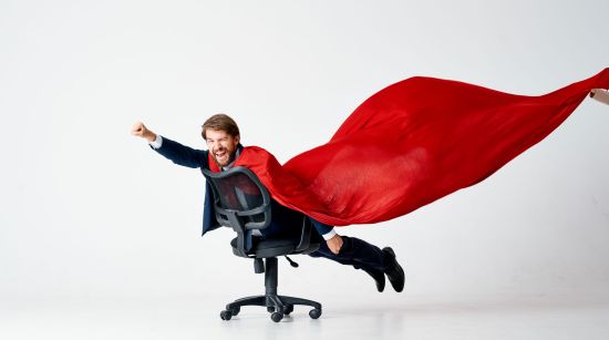 Mitarbeiter als Held auf Bürostuhl